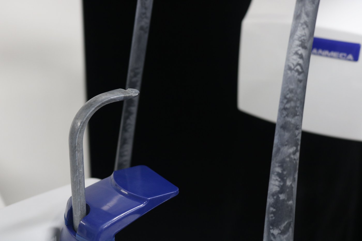 Red mushroom-style emergency stop safety button mounted on the column of the Planmeca ProOne panoramic X-ray unit