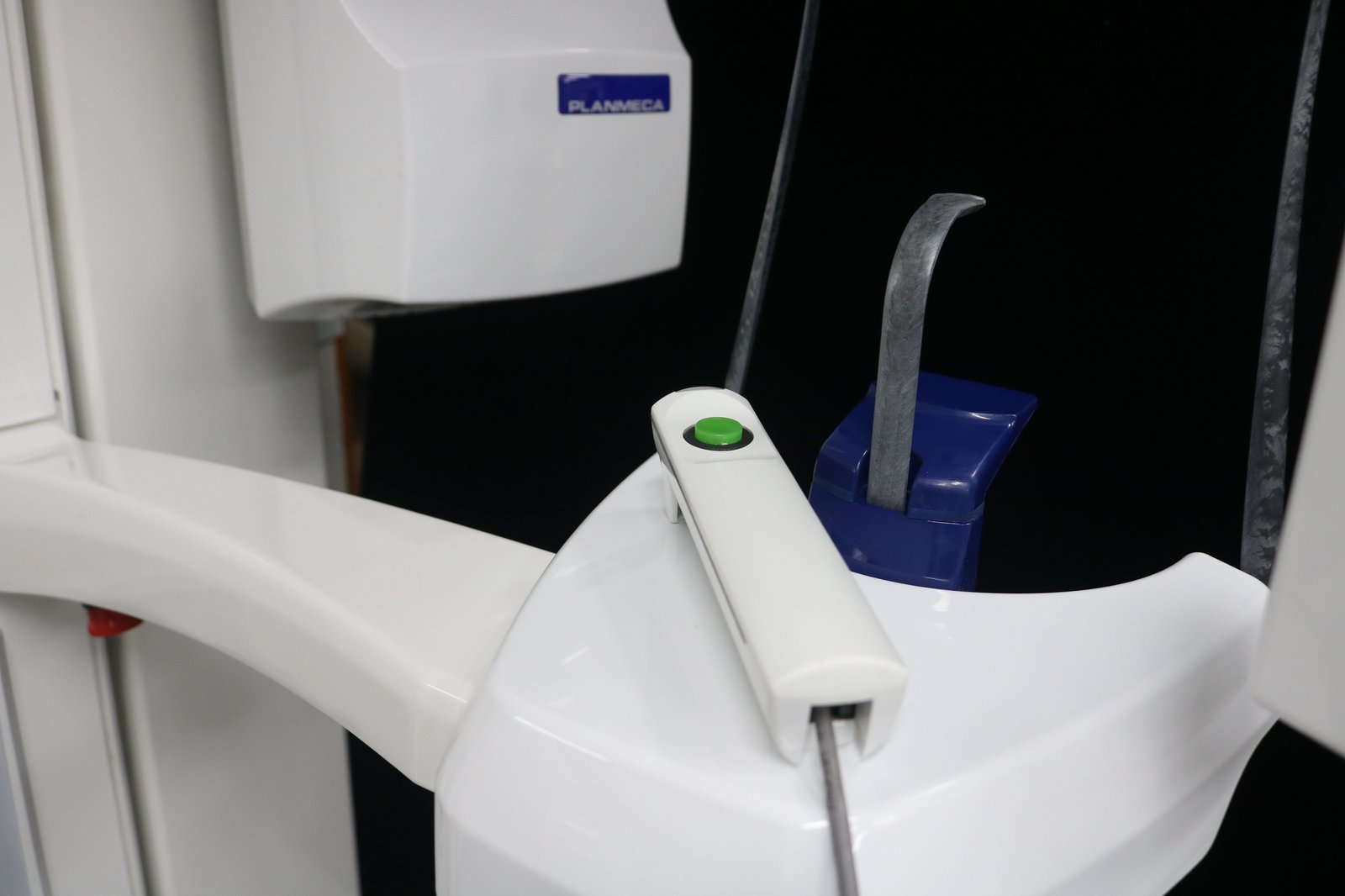 Patient positioning assembly of the Planmeca ProOne — dual metal temple support arms and blue disposable bite block holder