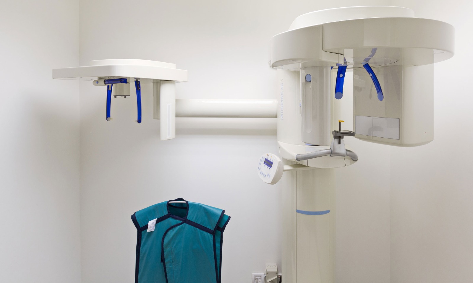 Dentist operating Planmeca ProMax 2D at the touchscreen control panel