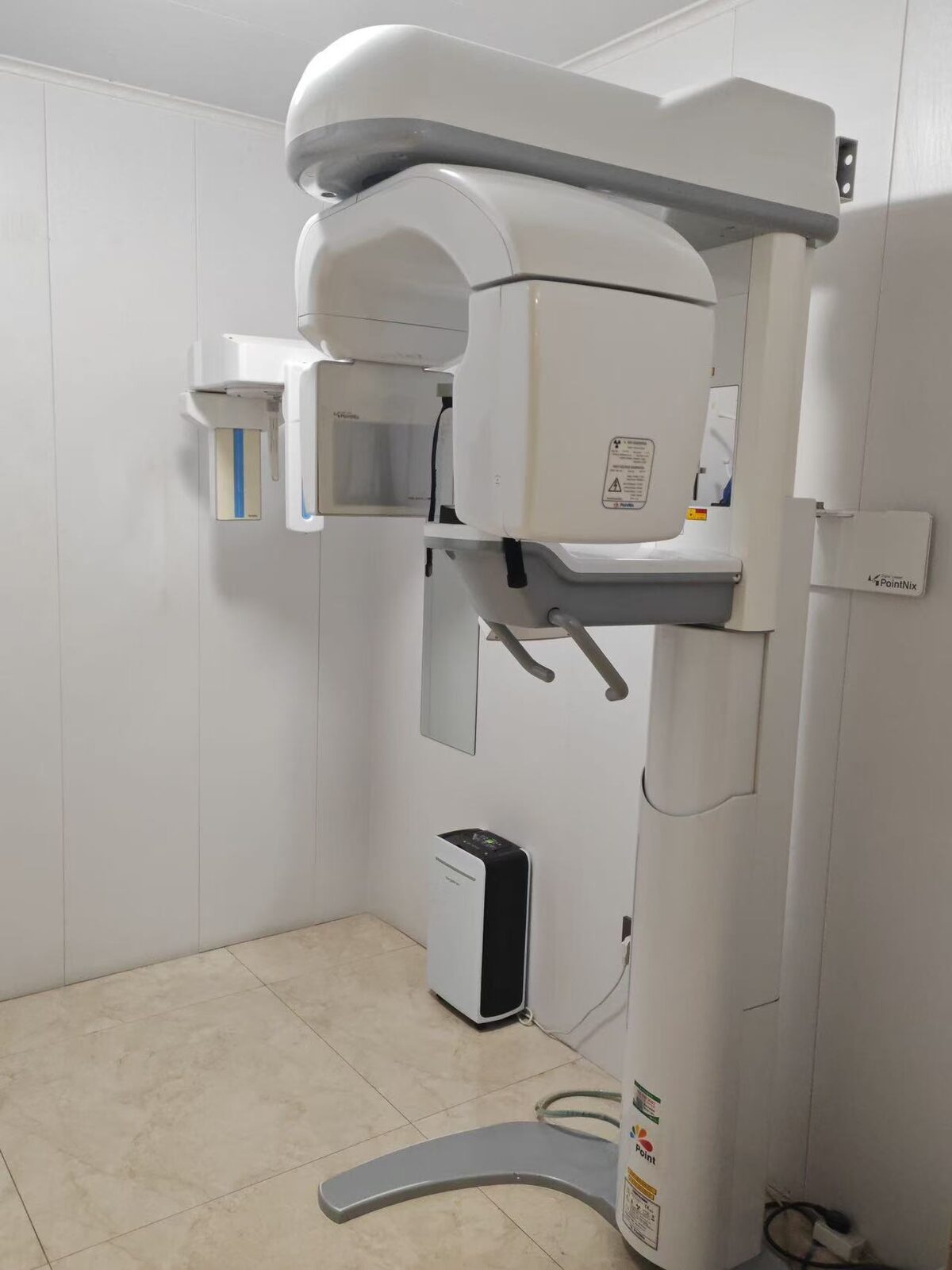 PointNix Point 800S HD 3D Plus CBCT installed in a clinic treatment room — full unit view with Ceph sensor on the left, main gantry, base with Point logo, and visible PointNix safety labels