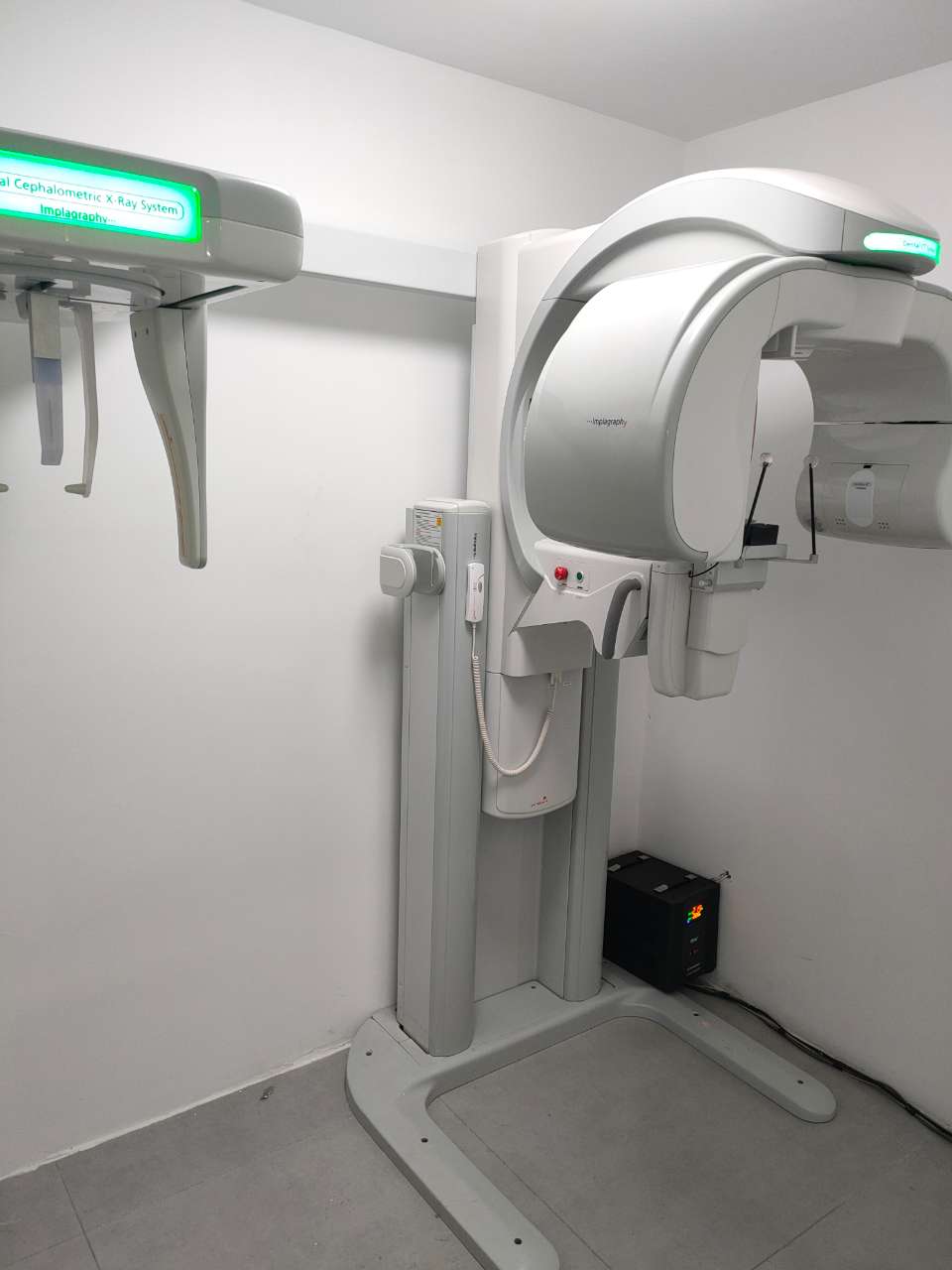 Complete VATECH Implagraphy CBCT installation — cephalometric X-ray arm on left and 3D CBCT main unit on right, room-ready setup