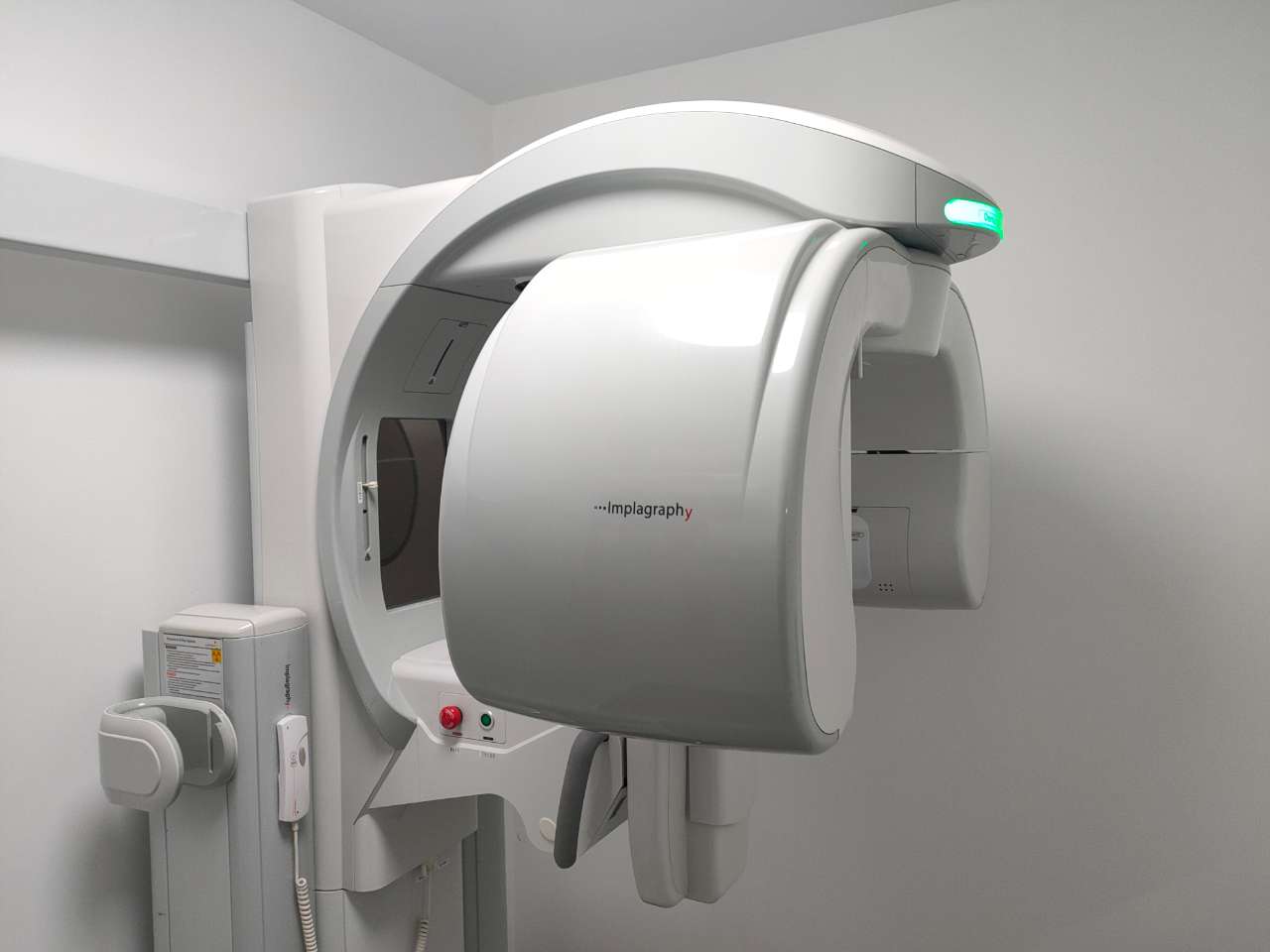 VATECH Implagraphy dental CBCT rotating gantry — close-up of C-arm with Implagraphy branding and status LED